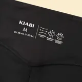 Legging deportivo negro de tiro alto con diseño de cintura cruzada en forma de V, confeccionado en tejido elástico y ajustado.