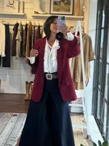 Blazer de corte sastre en color gris claro, con solapas clásicas, bolsillos frontales con solapa y mangas con detalle de frunce.