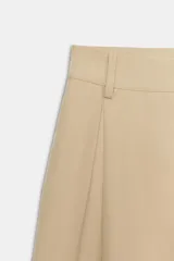 Bermuda larga cargo de color beige, confeccionada en mezcla de algodón. Cuenta con tiro medio, cintura con trabillas, pinzas en el delantero y bolsillos estilo cargo en las piernas.