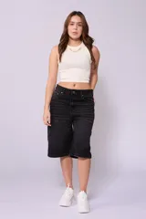 Bermuda de jean negro con corte baggy y largo a la rodilla.