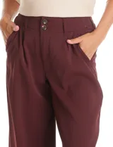 Pantalón tipo palazzo de corte ancho y fluido, confeccionado en tejido sastrero. Presenta tiro alto con doble abotonadura frontal, pinzas decorativas y cintura elástica en la parte posterior. Incluye bolsillos laterales funcionales.