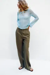 Pantalón recto de lino color verde militar, de tiro medio con cintura elástica ajustable mediante cordón y bolsillos delanteros.