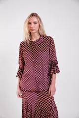Camisa amarilla de manga larga con diseño de cuadros de terciopelo, cuello clásico y mangas con volados en los puños.