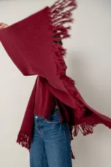 Ruana de lana color beige, tejida en punto acanalado con terminación de flecos en los bordes.
