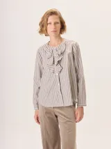 Camisa de corte recto y manga larga, con diseño a rayas verticales y detalle de volados en el frente. Confeccionada en algodón.