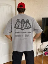 Remera oversize gris con efecto acid wash y estampa frontal con la leyenda "WORLDWIDE TOUR" en tipografía gótica.