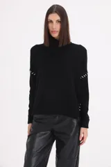 Sweater de cuello alto tipo polera, color negro, con detalle de pespuntes decorativos en color blanco en las mangas y laterales.