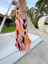 Vestido largo de fibrana con estampado abstracto multicolor, breteles finos y falda con volantes.