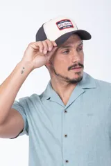 Gorro tipo gorra azul con visera curva y la letra 'U' bordada en el frente en color rojo con contorno blanco.