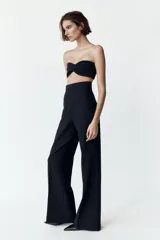 Pantalón de vestir color crudo, de tiro alto y pierna acampanada.