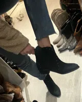 Bota corta de cuero vacuno color negro, con punta fina y tachas plateadas.