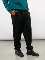 Pantalón de jogging de felpa con friza, color gris, con cintura elástica, bolsillos laterales y puños en los tobillos. Presenta un parche con el logo de Umbro en la parte superior delantera.