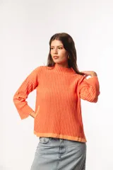 Sweater de punto acanalado color coral, con cuello alto y mangas largas con puños acampanados.