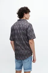 Camisa negra con estampado cachemir en blanco, de manga corta y corte recto.