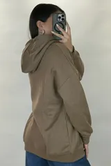Canguro deportivo de corte oversize, color beige, con capucha ajustable, bolsillo frontal tipo canguro y puños elásticos en mangas y ruedo.