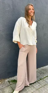 Sobrecamisa de viscosa con detalles de lúrex, color marfil, con escote en V, cierre frontal abotonado y mangas abullonadas.