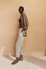 Pantalón de tiro medio color amarillo, con cintura elástica, bolsillos de plastrón en el delantero y pernera holgada que se estrecha hacia el tobillo. Cuenta con cierre frontal de cremallera y botón.