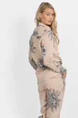 Camisa color beige con estampado de flores y tigres en blanco y negro, de corte clásico y manga larga.