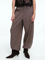 Pantalón de silueta holgada y cómoda, color gris, con cintura elástica y bajo ajustable mediante cordón. Cuenta con bolsillos laterales ocultos y diseño de estilo babucha.