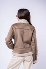 Campera tipo gamulán de corte recto, confeccionada en cuero sintético color tostado con interior y solapas de corderito sintético en tono crema. Presenta cierre frontal cruzado, bolsillos laterales con cierre y cinturón ajustable en el ruedo.