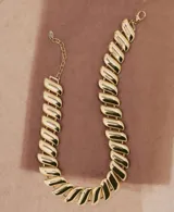 Collar de eslabones metálicos dorados con acabado brillante, de diseño plano y articulado, con cadena de alargue y cierre de mosquetón.