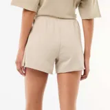Short de felpa beige de corte holgado, con cintura elástica ajustable mediante cordón y bolsillos laterales.