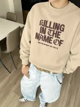 Buzo color beige con estampado frontal en marrón con la frase "Killing in the Name of", cuello redondo, mangas largas y puños y cintura de rib.