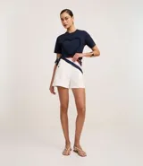 Remera marrón de algodón con cuello redondo y mangas cortas. Presenta un aplique de corazón con volados en el frente.