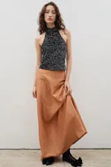 Falda larga de corte semi acampanado, confeccionada en tela con textura arrugada y acabado satinado.