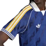 Camiseta de fútbol Adidas Originals del Real Madrid, color azul oscuro con estampado jacquard de logotipos. Presenta cuello polo blanco, mangas con las icónicas tres tiras en amarillo y detalles en blanco y azul en los puños.