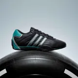 Championes Adidas Adiracer de perfil bajo inspirados en el automovilismo, en color negro con detalles plateados y turquesa. Presentan diseño de tres tiras en los laterales, empeine de cuero con inserciones sintéticas y suela de goma.