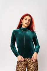 Polera de manga larga color verde petróleo con detalle de drapeado en las mangas. Confeccionada en terciopelo velvet con lurex.