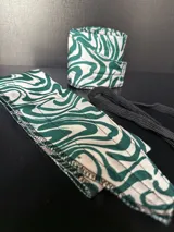 Par de muñequeras de boxeo con estampado de cebra en verde y blanco, con cierre de velcro y cordón elástico negro.