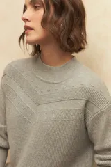 Polera de cuello redondo tejida en color marrón, con detalle de textura en el canesú y puños elastizados.