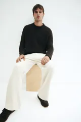 Pantalón de pana color beige, de corte relaxed fit, con cintura clásica, cierre de botón, bolsillos laterales y bolsillos traseros insertados.