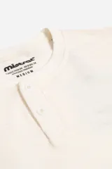 Remera de manga larga con cuello henley y cartera frontal de dos botones, confeccionada en tejido con textura.