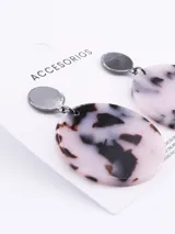 Aros colgantes con base circular negra y dije circular con estampado animal print en tonos blanco y negro.