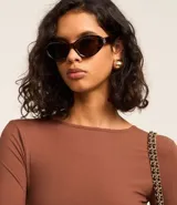 Body marrón de microfibra texturizada, con cuello redondo, mangas largas y escote en U en la espalda con tiras cruzadas.