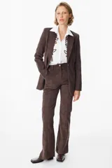 Blazer de corte clásico confeccionado en tela aterciopelada color bordó, con cuello solapa, cierre frontal con botones y bolsillos laterales tipo ojal.