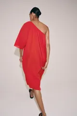 Vestido midi de punto rojo, amplio y de diseño asimétrico con un solo hombro y una manga corta.