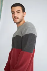 Sweater de tejido de punto con diseño color block en tonos verde, azul y gris. Presenta cuello redondo, mangas largas y corte regular.