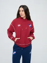 Canguro deportivo Umbro del Club Nacional de Football, color bordó, con capucha ajustable con cordón, bolsillo tipo canguro y costuras visibles en contraste. Presenta el logo de Umbro y el escudo del club bordados en el frente.