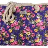 Cartera tipo tote bag de gran tamaño con estampado floral en tonos rosas y amarillos sobre fondo azul. Cuenta con manijas de cuerda gruesa en color natural.