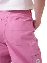 Pantalón de carpintero marca Cat, color rosado, de corte relajado, con bolsillos utilitarios, presilla para martillo y cierre frontal con botón y cremallera.