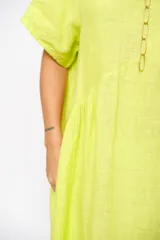 Vestido midi verde flúor de lino, corte holgado, escote redondo y manga corta.