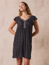 Camisón corto negro con estampado de lunares blancos, escote en V con puntilla blanca y botones.