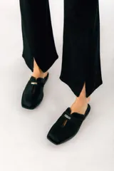 Zuecos de cuero color bordó con punta cuadrada, detalle de abertura en el empeine y aplique metálico dorado.