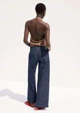 Pantalón jeans de corte wide leg en azul marino, con tiro medio, pernera recta y ancha, y costuras frontales marcadas a lo largo de cada pierna.