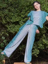 Pantalón de lino y algodón a rayas verticales en tonos celeste y blanco, con corte palazzo y volados en el lateral.