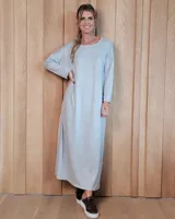 Vestido largo de lanilla en color gris melange, de corte holgado y diseño minimalista. Presenta cuello redondo, mangas largas y un bolsillo frontal tipo parche en el pecho.